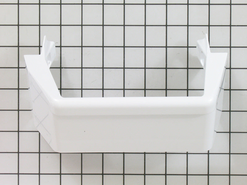 A white Whirlpool refrigerator door shelf trim against a checkered background. A white Whirlpool refrigerator door shelf trim against a checkered background.